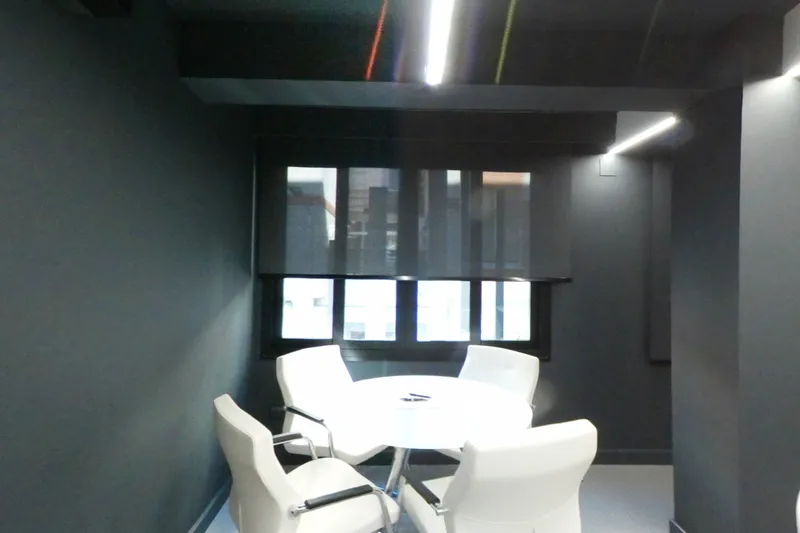 La mesa redonda de reuniones de un despacho, junto a la ventana