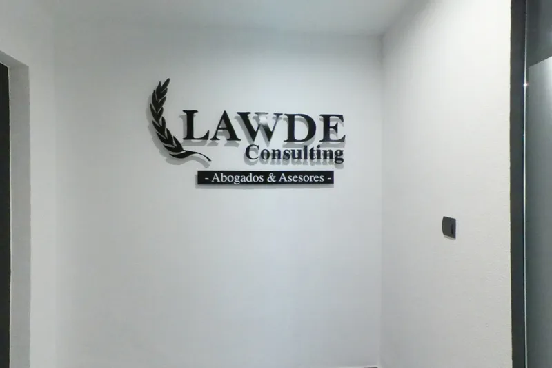 La entrada del despacho: el logotipo de LAWDE en la pared blanca del rellano