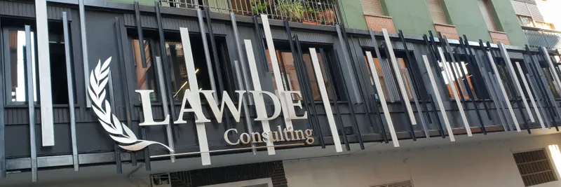 La fachada del edificio, con el rótulo de LAWDE en el balcón de lamas blancas