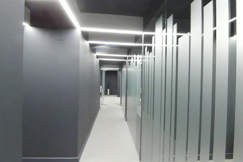 El pasillo central, con las líneas de luz del techo y las mamparas de cristal con franjas